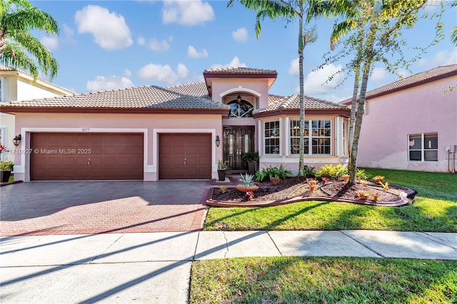 mediterranean / spanish-style house with a front yard and a garage