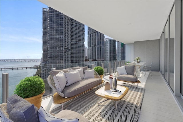 balcony with a water view and an outdoor hangout area