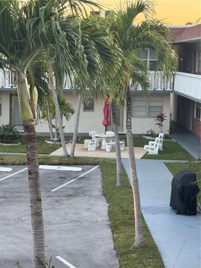 view of home's community featuring a lawn and a patio area