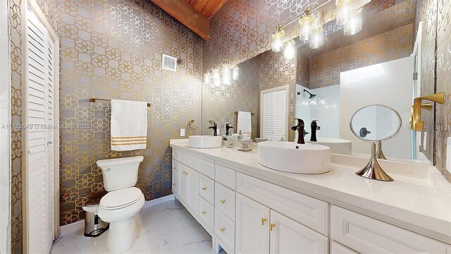 bathroom featuring beamed ceiling, vanity, and toilet