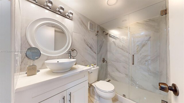 bathroom with vanity, toilet, and a shower with shower door