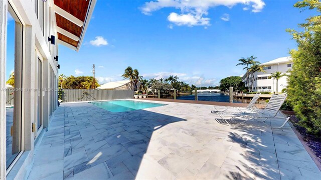 view of swimming pool featuring a patio area and a water view