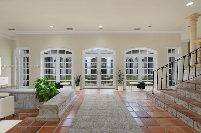 tiled foyer entrance featuring crown molding, a wealth of natural light, and french doors