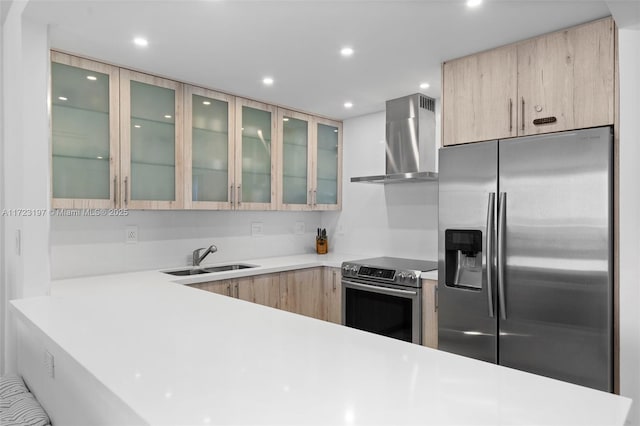 kitchen with sink, wall chimney exhaust hood, stainless steel appliances, light brown cabinets, and kitchen peninsula