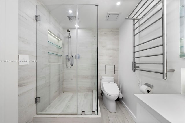 bathroom with radiator heating unit, toilet, and a shower with door