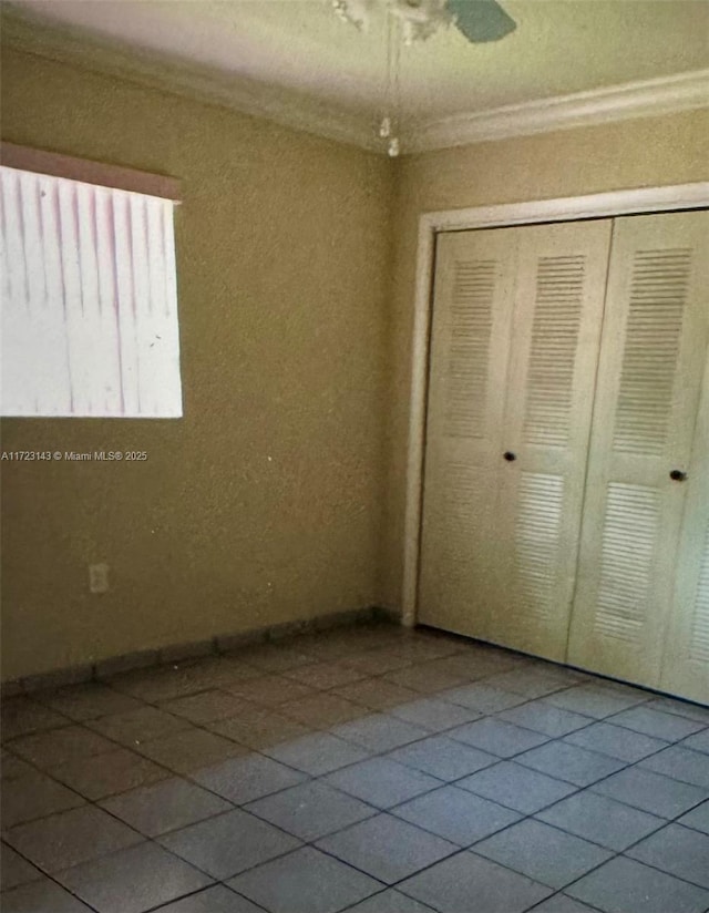 unfurnished bedroom with tile patterned flooring, a closet, and ceiling fan