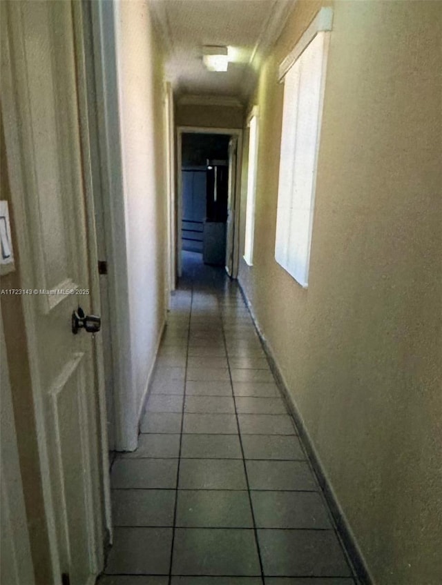 hall featuring tile patterned flooring and ornamental molding