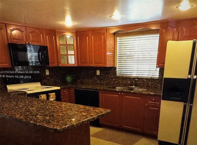 kitchen featuring dark stone countertops, white appliances, sink, and light tile patterned floors