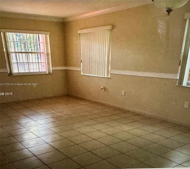 tiled spare room with ornamental molding