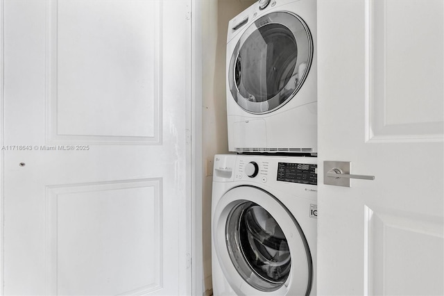 clothes washing area with stacked washer / dryer