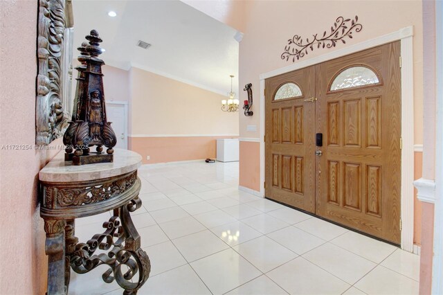 tiled foyer entrance with a chandelier and ornamental molding