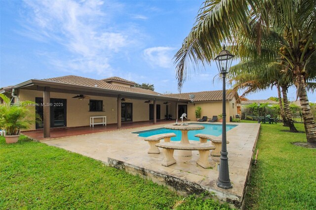 view of swimming pool featuring a patio area, ceiling fan, and a yard