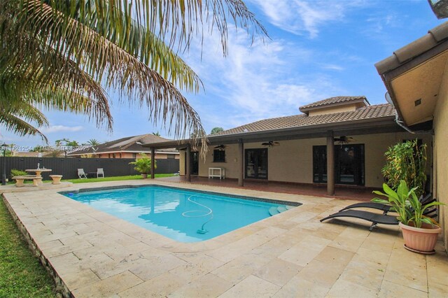 view of swimming pool featuring ceiling fan and a patio area