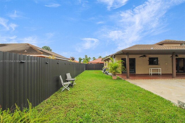 view of yard featuring ceiling fan and a patio