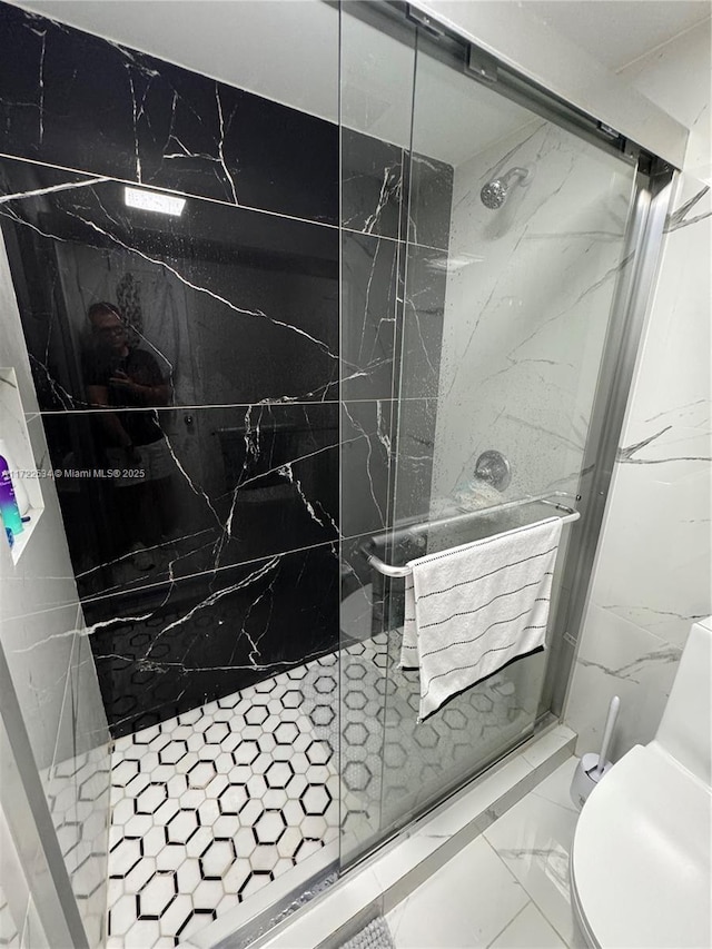 bathroom featuring toilet and a tile shower