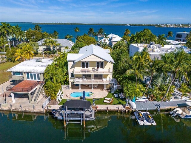 rear view of house featuring a balcony, ceiling fan, and a water view