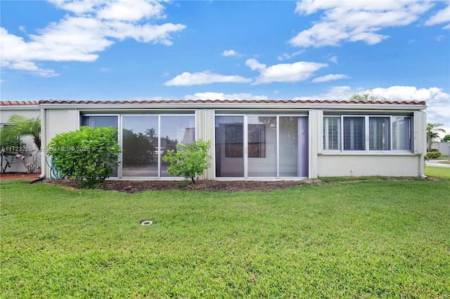 rear view of property featuring a yard