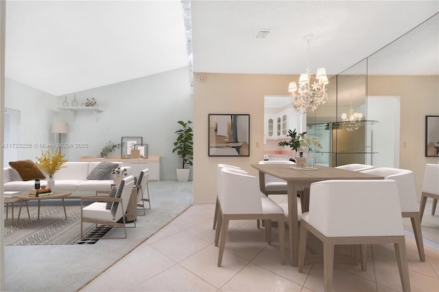 dining space with light tile patterned floors, vaulted ceiling, and an inviting chandelier