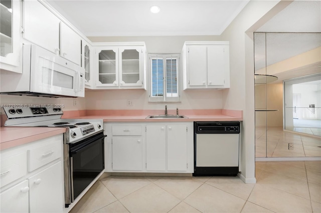 kitchen featuring white cabinetry, sink, light tile patterned flooring, and white appliances