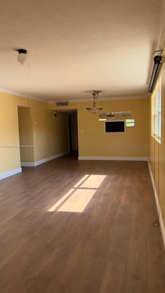 unfurnished living room featuring wood-type flooring and ornamental molding