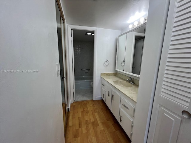 bathroom with hardwood / wood-style floors, vanity, and toilet