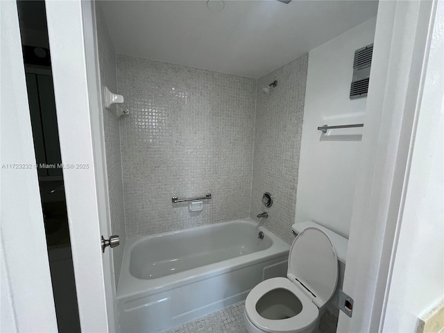 bathroom featuring tile patterned floors, toilet, and tiled shower / bath