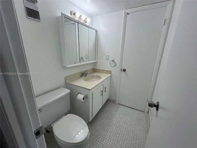 bathroom with tile patterned floors, vanity, and toilet