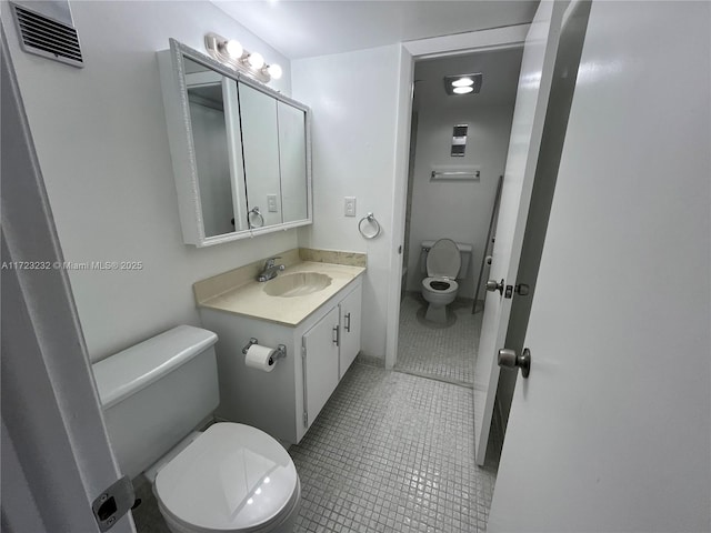 bathroom with tile patterned flooring, vanity, and toilet