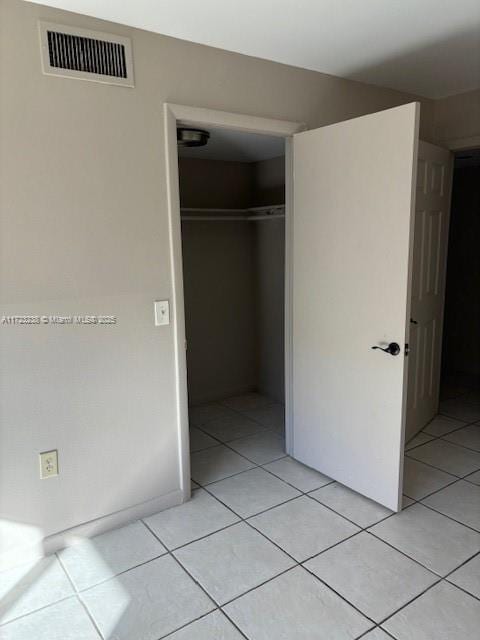 unfurnished bedroom featuring a closet and light tile patterned floors