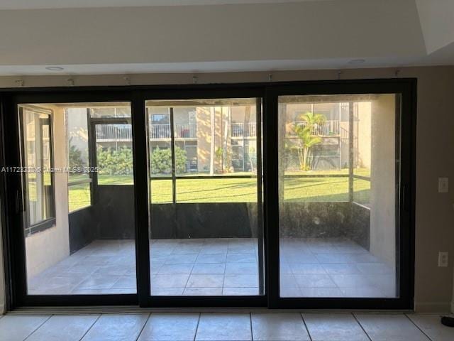 doorway to outside with plenty of natural light and light tile patterned flooring