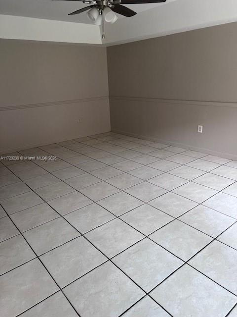 tiled spare room featuring ceiling fan