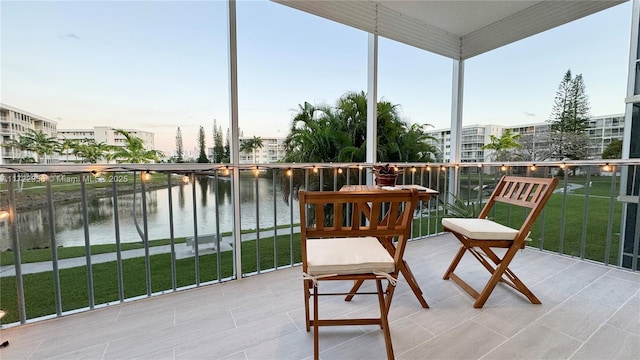 sunroom featuring a water view