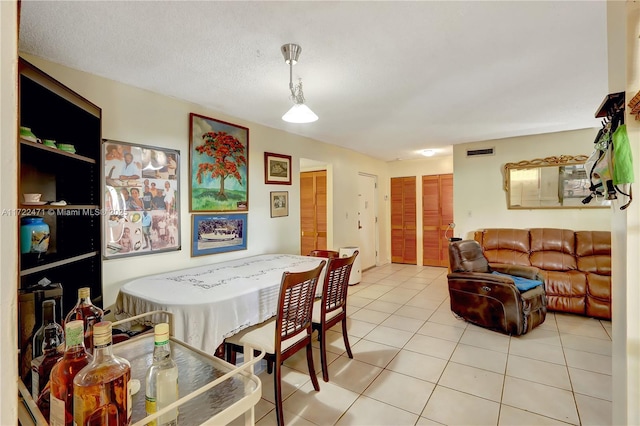 tiled dining space featuring a textured ceiling