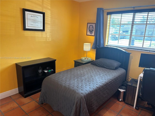 tiled bedroom featuring baseboards