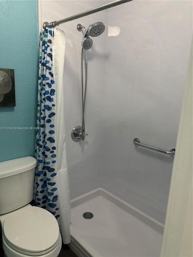 full bath with a stall shower and toilet