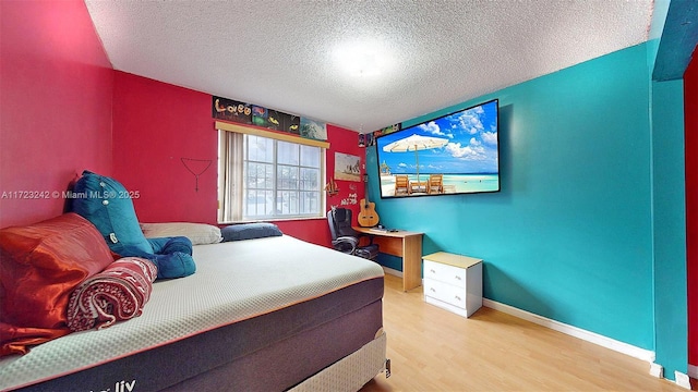 bedroom with hardwood / wood-style flooring and a textured ceiling