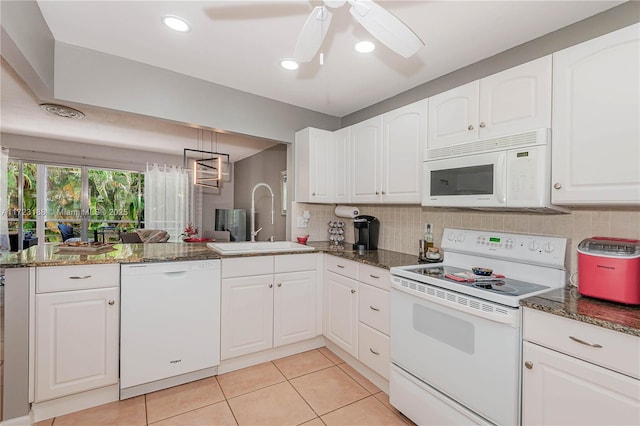 kitchen featuring a peninsula, white appliances, a sink, and white cabinetry