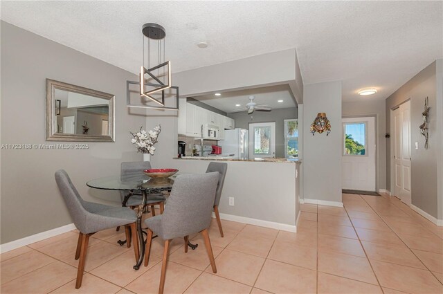 dining space with light tile patterned floors and a textured ceiling