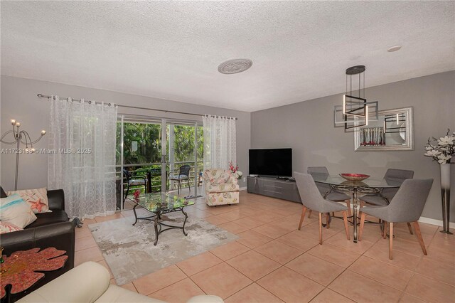 living room with ceiling fan, light tile patterned floors, and a textured ceiling