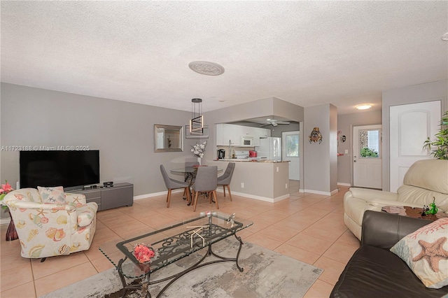 living room featuring ceiling fan, light tile patterned floors, and a textured ceiling