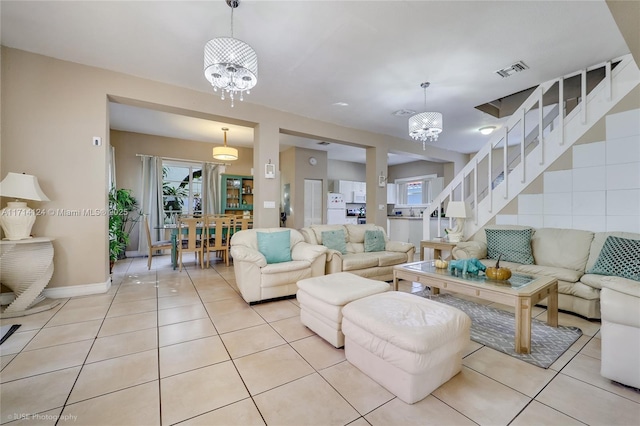 living room featuring light tile patterned floors and an inviting chandelier