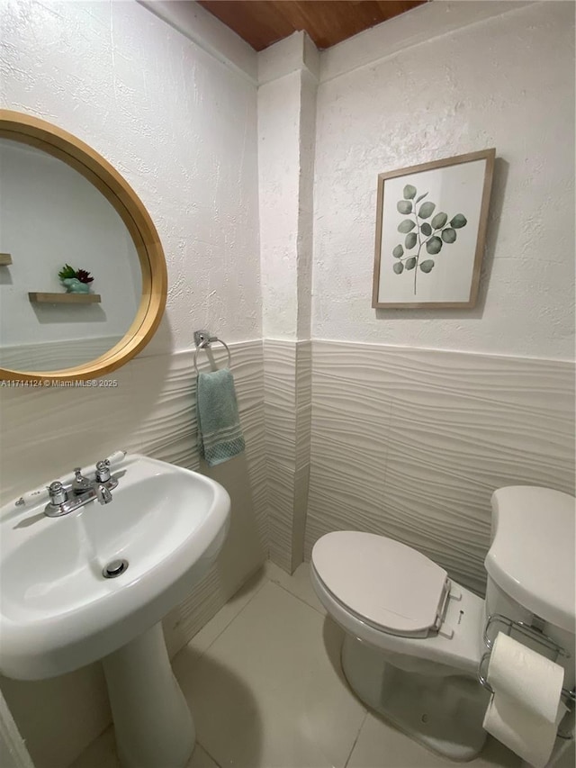 bathroom with tile walls, toilet, and tile patterned flooring