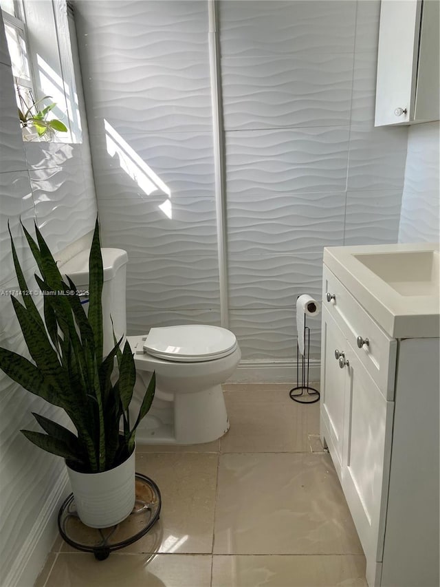 bathroom with toilet, tile patterned floors, and vanity