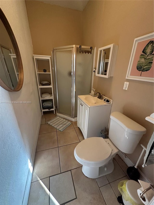 bathroom featuring a shower with shower door, tile patterned floors, vanity, and toilet