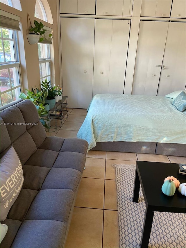 tiled bedroom featuring multiple closets