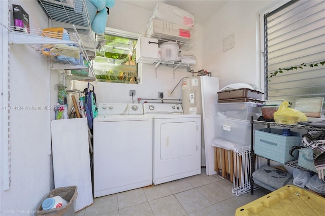 clothes washing area featuring light tile patterned floors and independent washer and dryer