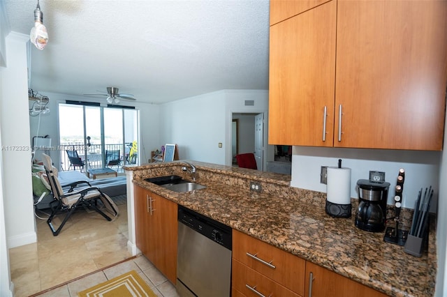 kitchen featuring sink, dishwasher, ceiling fan, dark stone countertops, and light tile patterned flooring