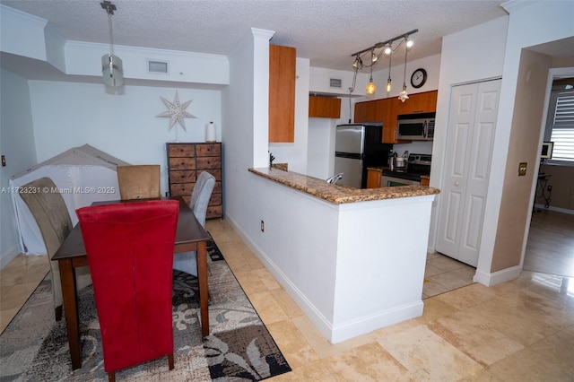 kitchen featuring hanging light fixtures, stainless steel appliances, kitchen peninsula, and a textured ceiling