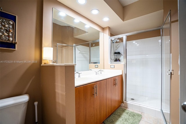 bathroom with toilet, vanity, tile patterned floors, and walk in shower