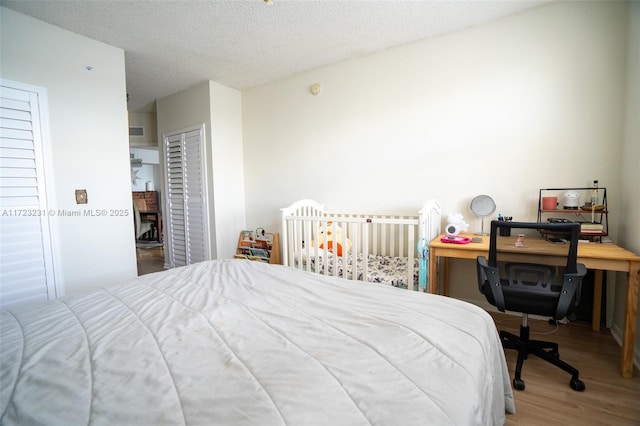 bedroom with hardwood / wood-style flooring, a textured ceiling, and a closet